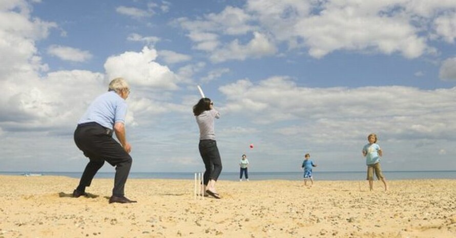 Drei Generationen spielen am Strand gemeinsam Cricket. Foto: picture-alliance
