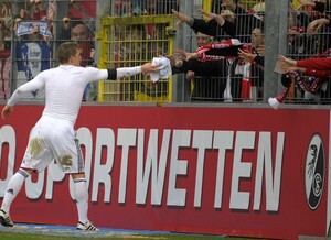 Bastian Schweinsteiger (Bayern München) vor einer Sportwetten-Werbung. Foto: picture-alliance