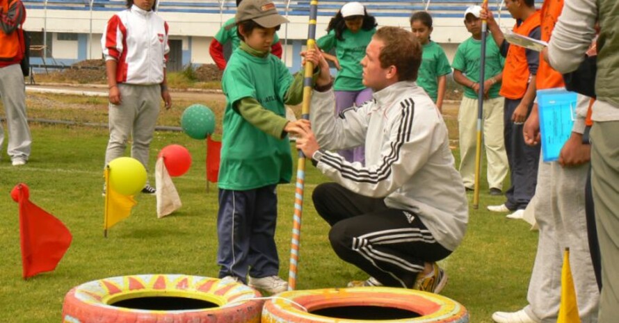 Junior-Experte Oliver Scheer erklärt Kindern den Stabweitsprung mit selbstgebasteltem Gerät. Foto: Björn Wangemann