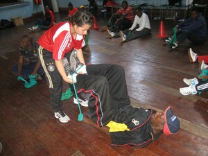 Laura Daras, Expertin für Stretching- und Krafttraining, zeigt einem simbabwischen Trainer die Arbeit mit dem Theraband. Foto: Pagels/DOSB
