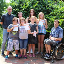 Gruppenfoto der zehn jungen Sportler/innen, die ihre Urkunden in den Händen halten, mit Stefan Doege (Sport-Inklusionsmanager der HpH) und Axel Wichmann (Schulleiter Paul-Moor-Schule). 