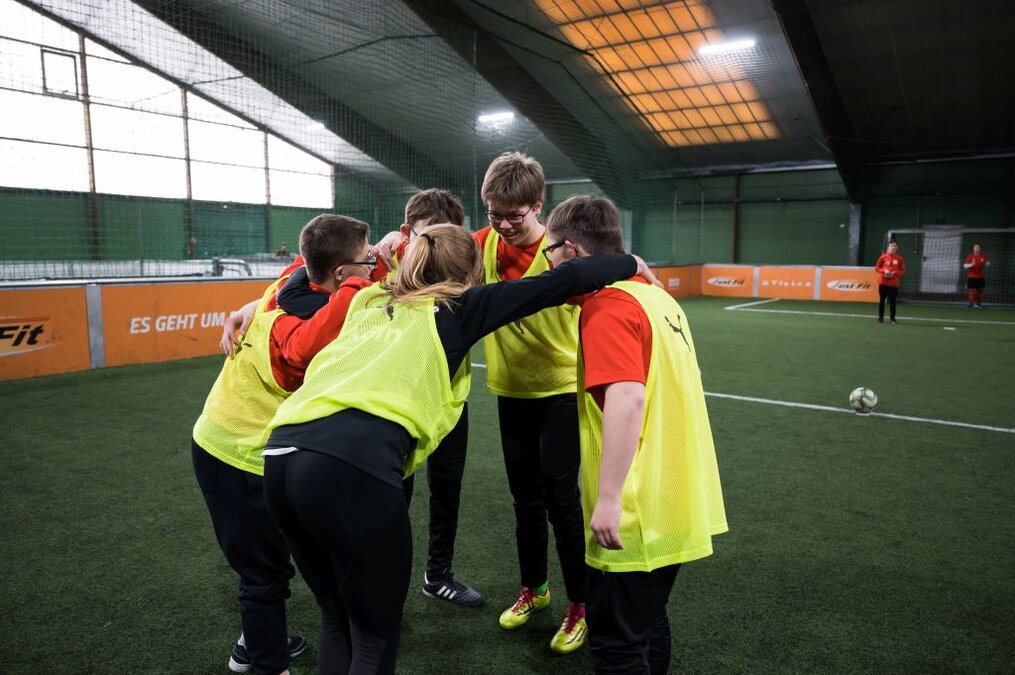 Jugendliche bilden einen Kreis auf einem Sportplatz Foto: LSB NRW
