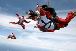 Spannung vor den Festtagen: Weihnachtsmänner und -frauen beim Fallschirmspringen. Copyright: picture-alliance