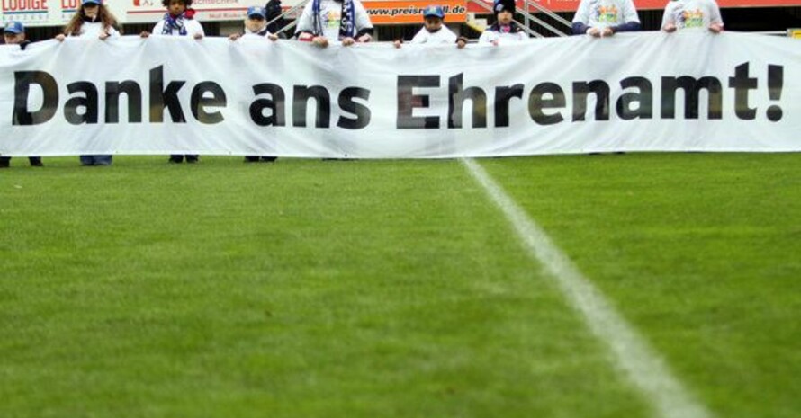 Jugendliche halten vor dem Anppfiff eines Fußballspiels ein Banner mit der Aufschrift: "Danke ans Ehrenamt". Foto: picture-alliance