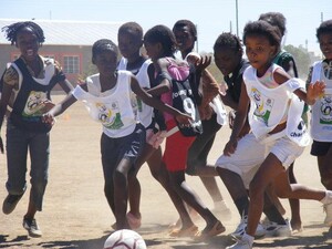 Die jüngsten Spielerinnen im namibischen Fußballverband rangeln um den Ball. Foto: Stärk