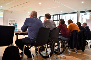 Sitzreihe mit Rollstuhl, Rückenansicht der Event-Inklusionsmanager*innen der 1. Phase / Foto: DOSB/Kai Peters