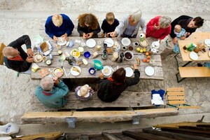 Eine Großfamilie frühstückt vor einer Hütte in den bayerischen Alpen. Foto: picture-alliance