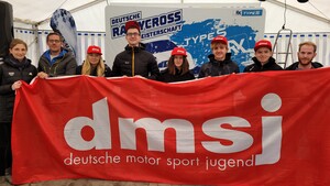 Acht Personen halten ein großes rotes Banner mit der Aufschrift dmsj deutsche motor sport jugend