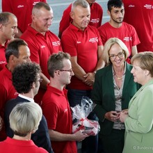 Leichtathlet Sebastian Kröger, Athletensprecher der Deutschen Delegation, überreichte Bundeskanzlerin Angela Merkel ein Delegationsbuch und ein T-Shirt als Gastgeschenk. Links neben der Kanzlerin steht SOD-Präsidentin Christiane Krajewski (Foto: Bundes