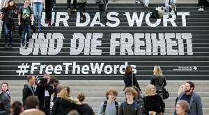 Besucher gehen über eine Treppe mit den Schriftzug «Für das Wort und die Freiheit» (#FreeTheWords) auf der Buchmesse in Leipzig im März 2017. Foto: picture-alliance